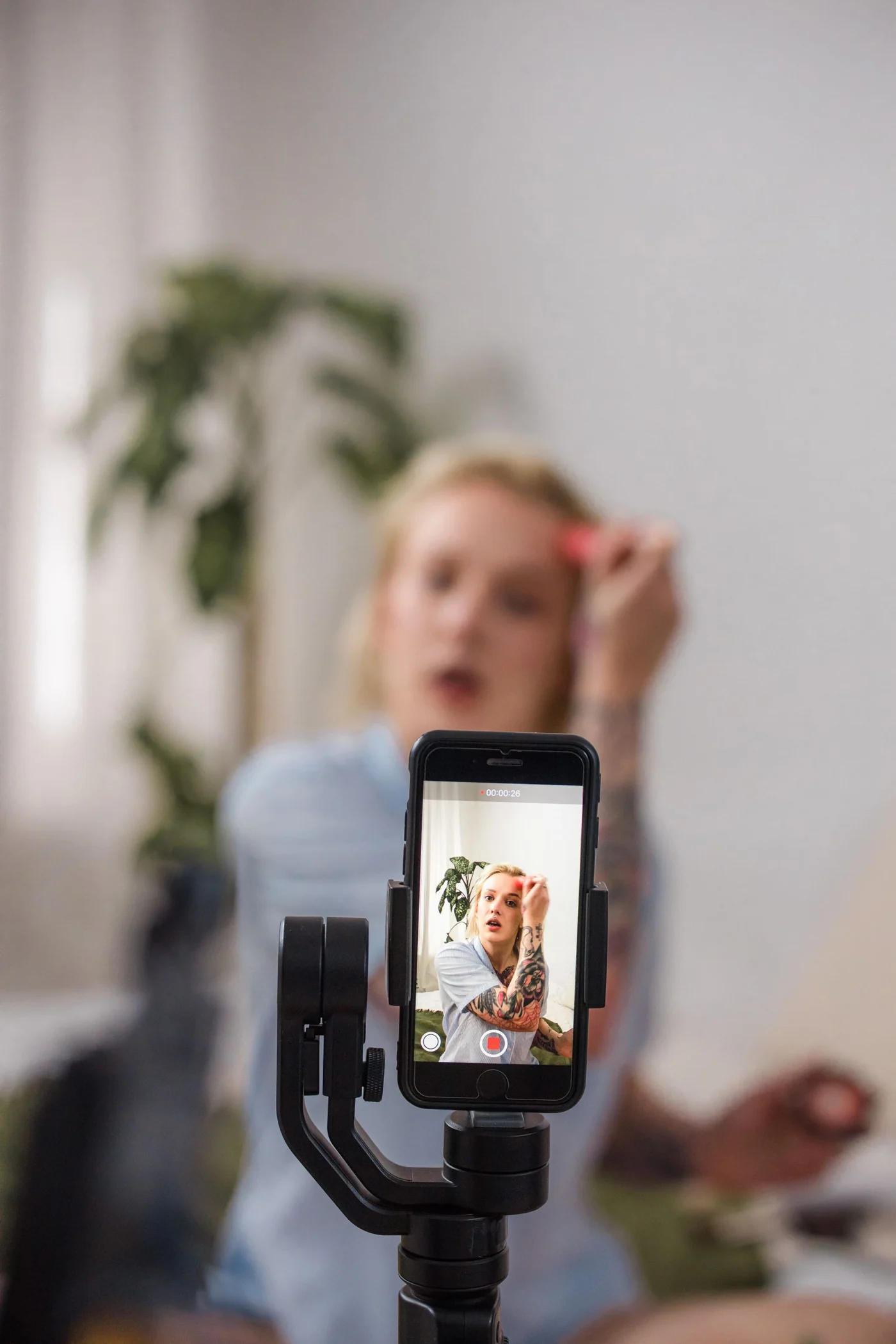 A beauty creator filming a tutorial on her smartphone